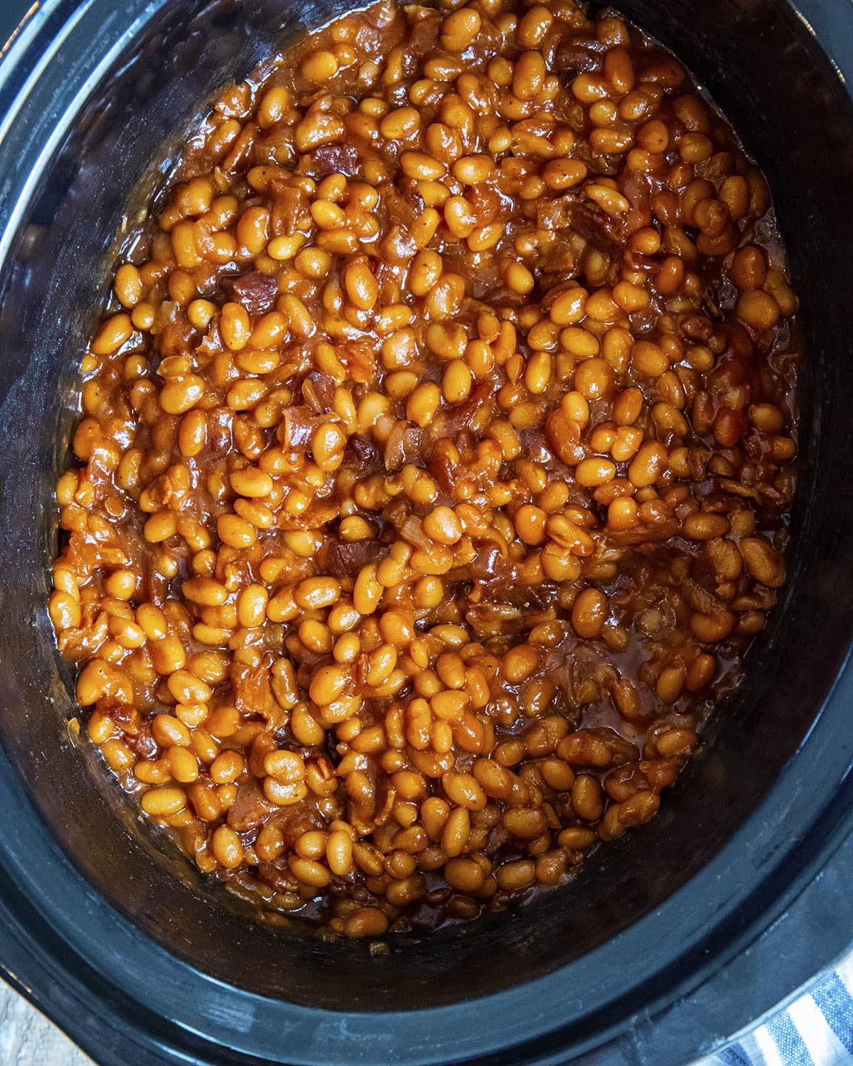 A slow cooker full of baked beans.