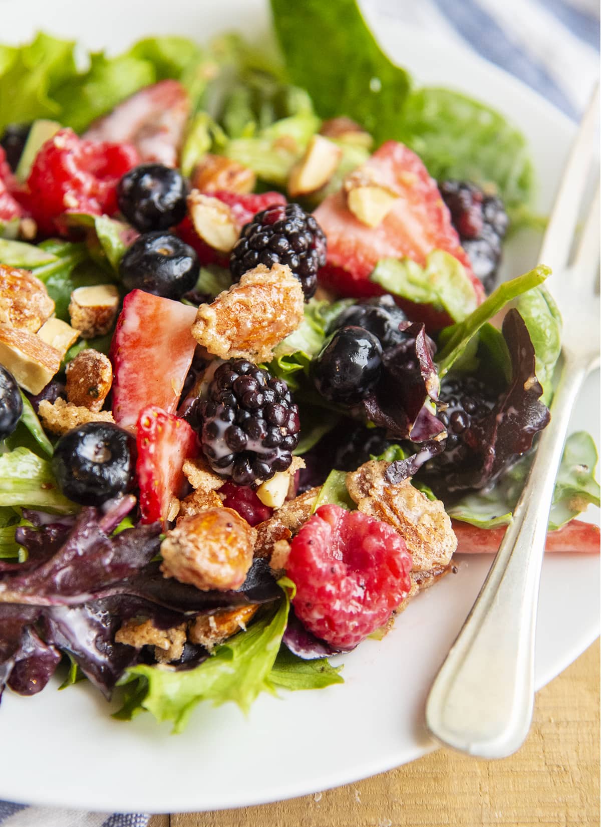 A summer berry salad tossed in poppy seed dressing on a plate.