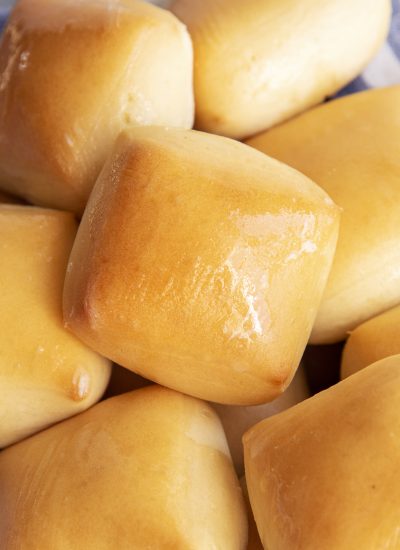 A close up of a basked of square style dinner rolls.