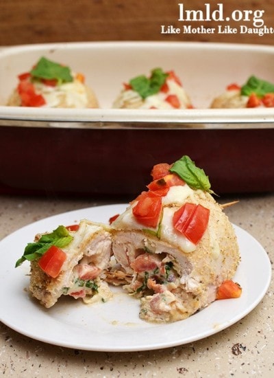 Angled view of italian stuffed chicken breast on a white plate.