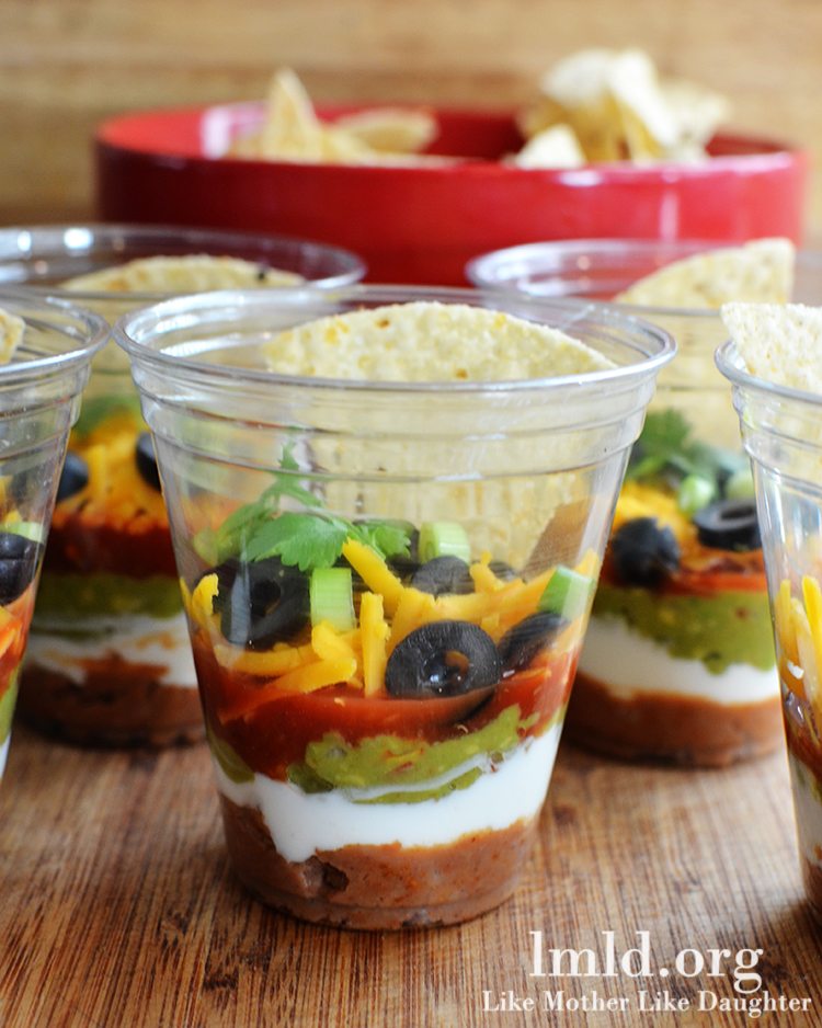 7 layer dip party cup with a chip in it inside of a clear cup.