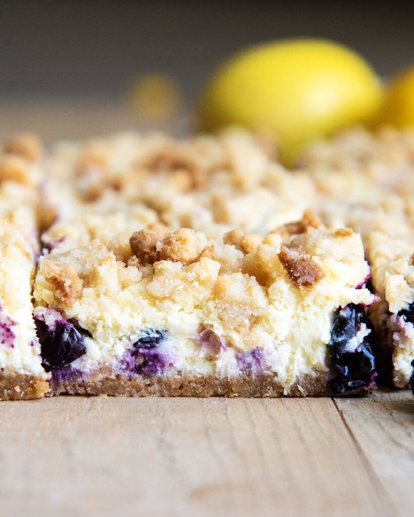 A side view of blueberry lemon cheesecake bars with streusel crumb topping.