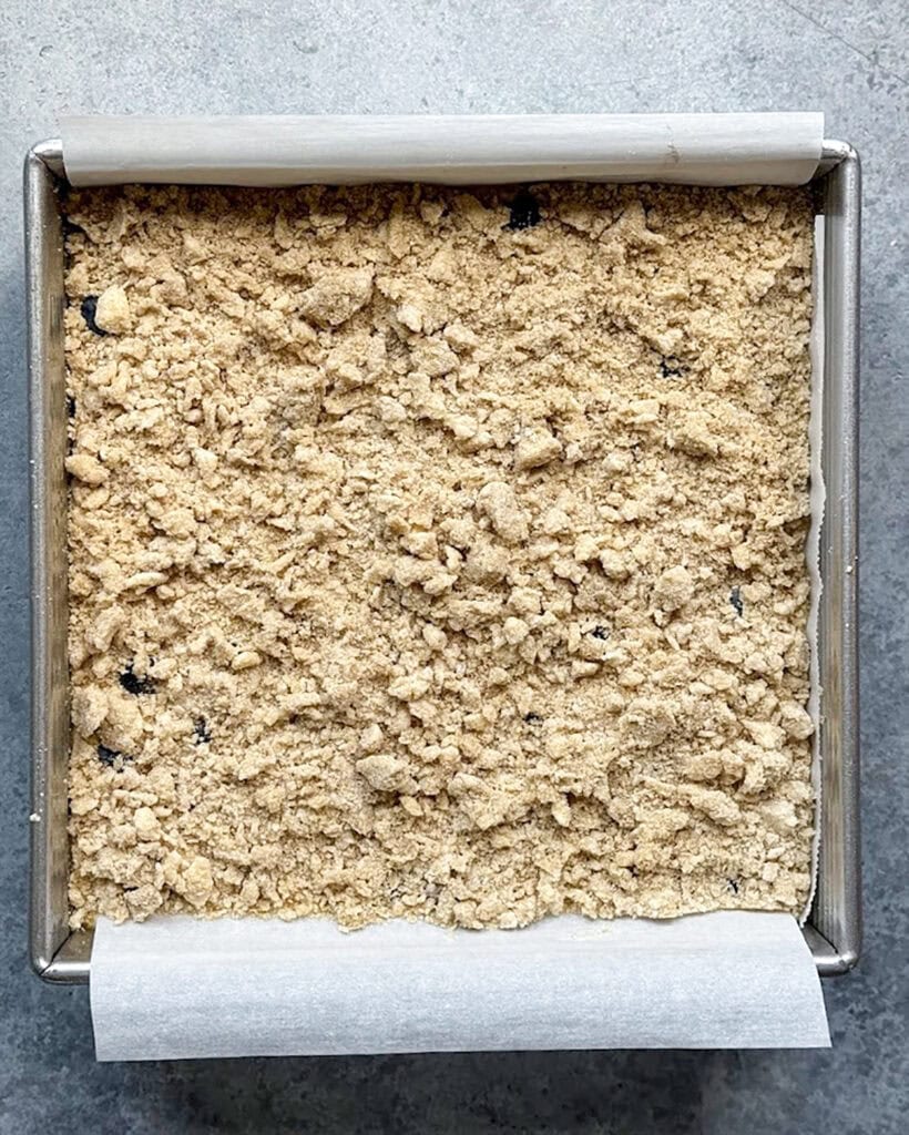 Unbaked cheesecake bars topped with a crumb topping.