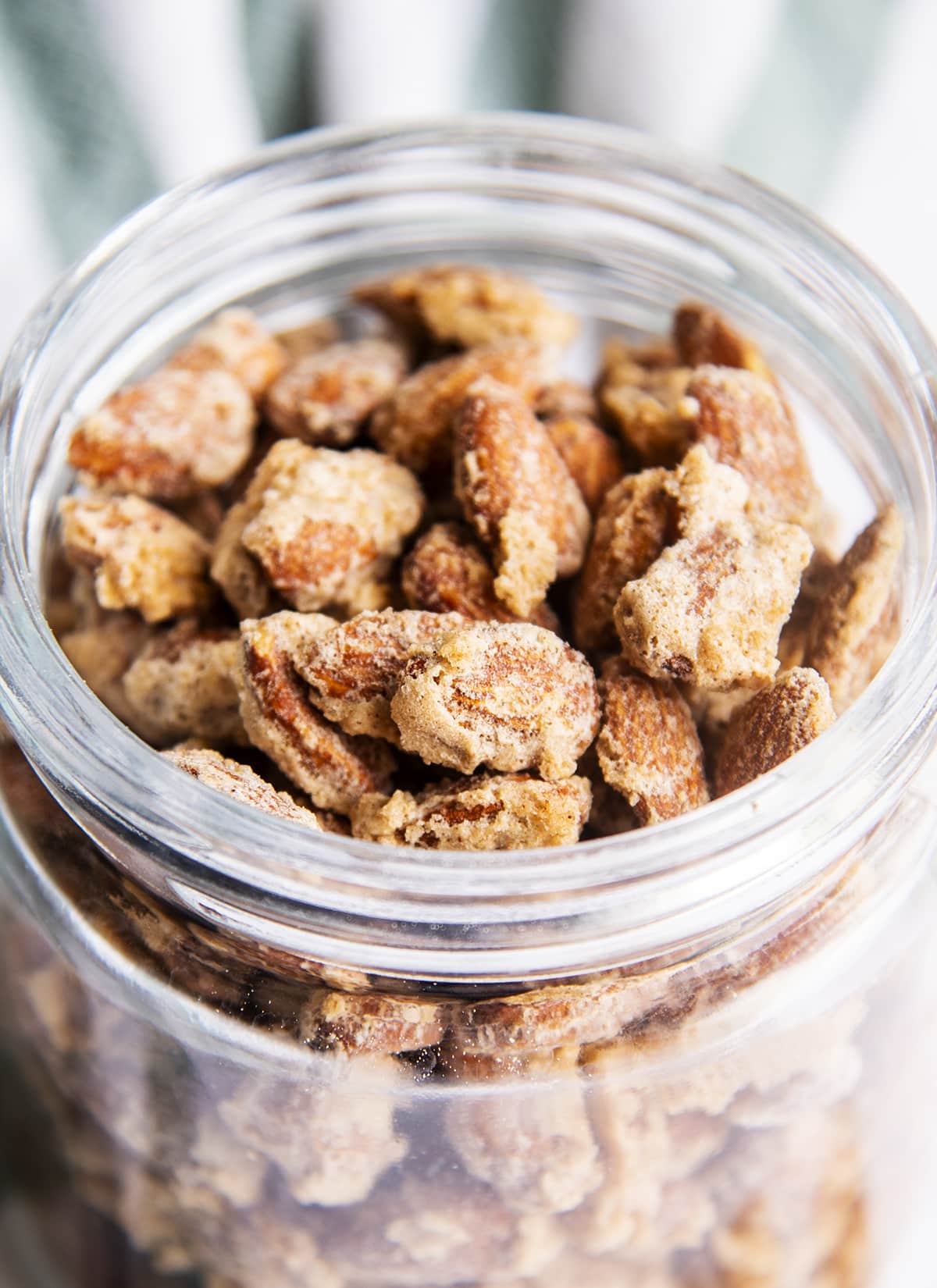 A close up of cinnamon sugar candied almonds in a jar.