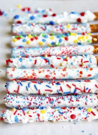 A row of pretzel "sparklers", which are pretzel rods dipped in chocolate and patriotic sprinkles.