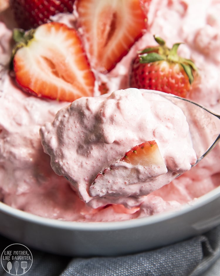 A spoonful of strawberry jello fluff above the whole bowl.