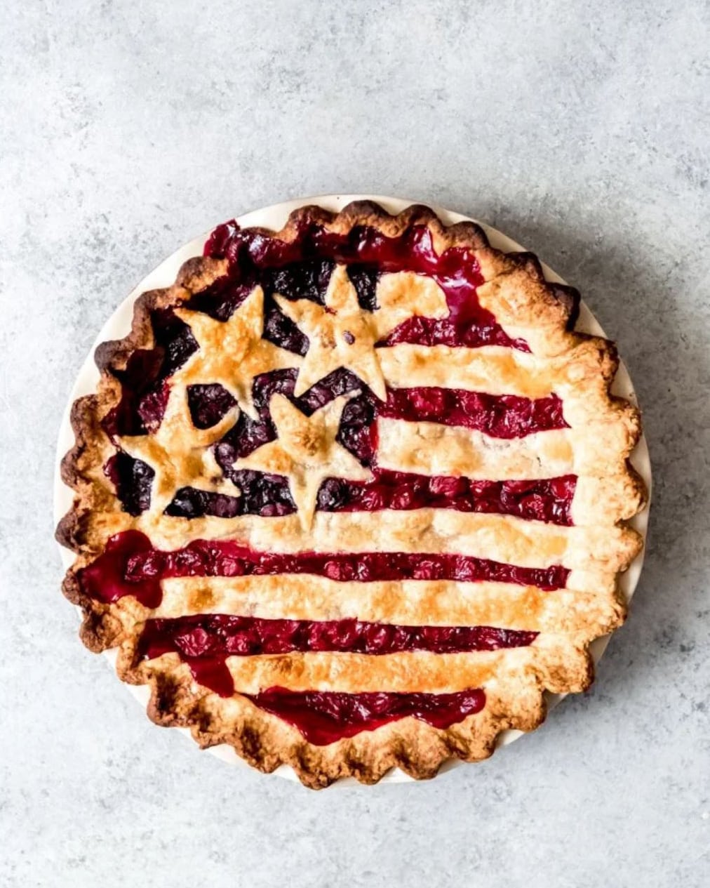 A pie decorated with red and blue berries, and stars and striped pie crust to look like the American flag.