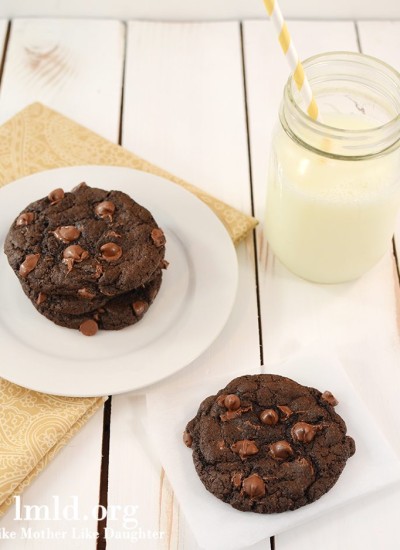 Angled view of double chocolate cookies for two on a white plate with milk.