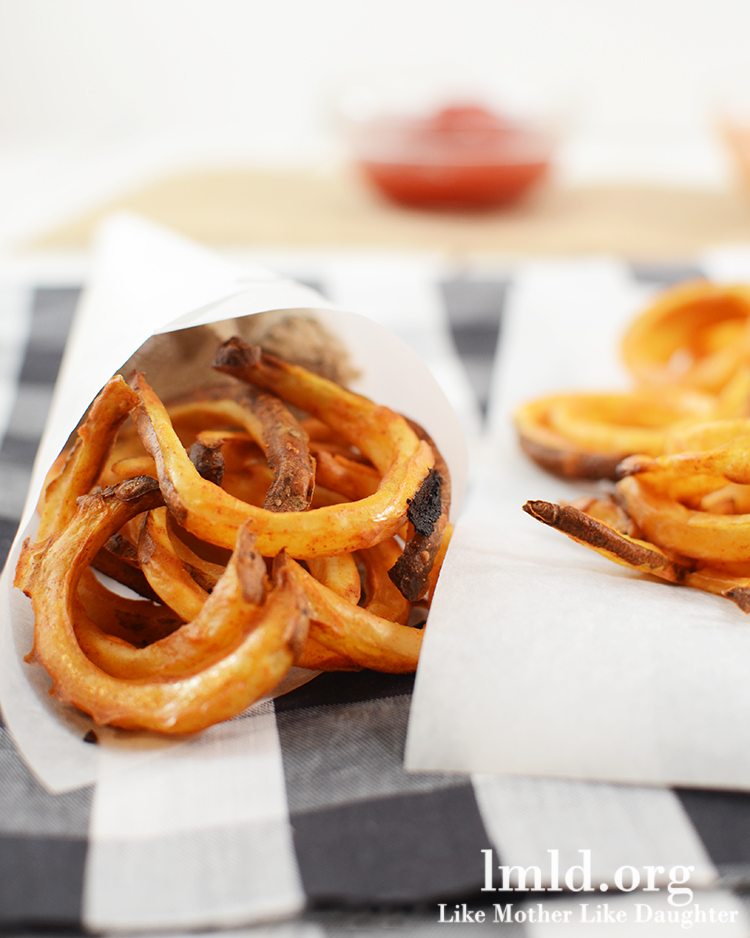 Front view of oven baked curly fries on a napkin.
