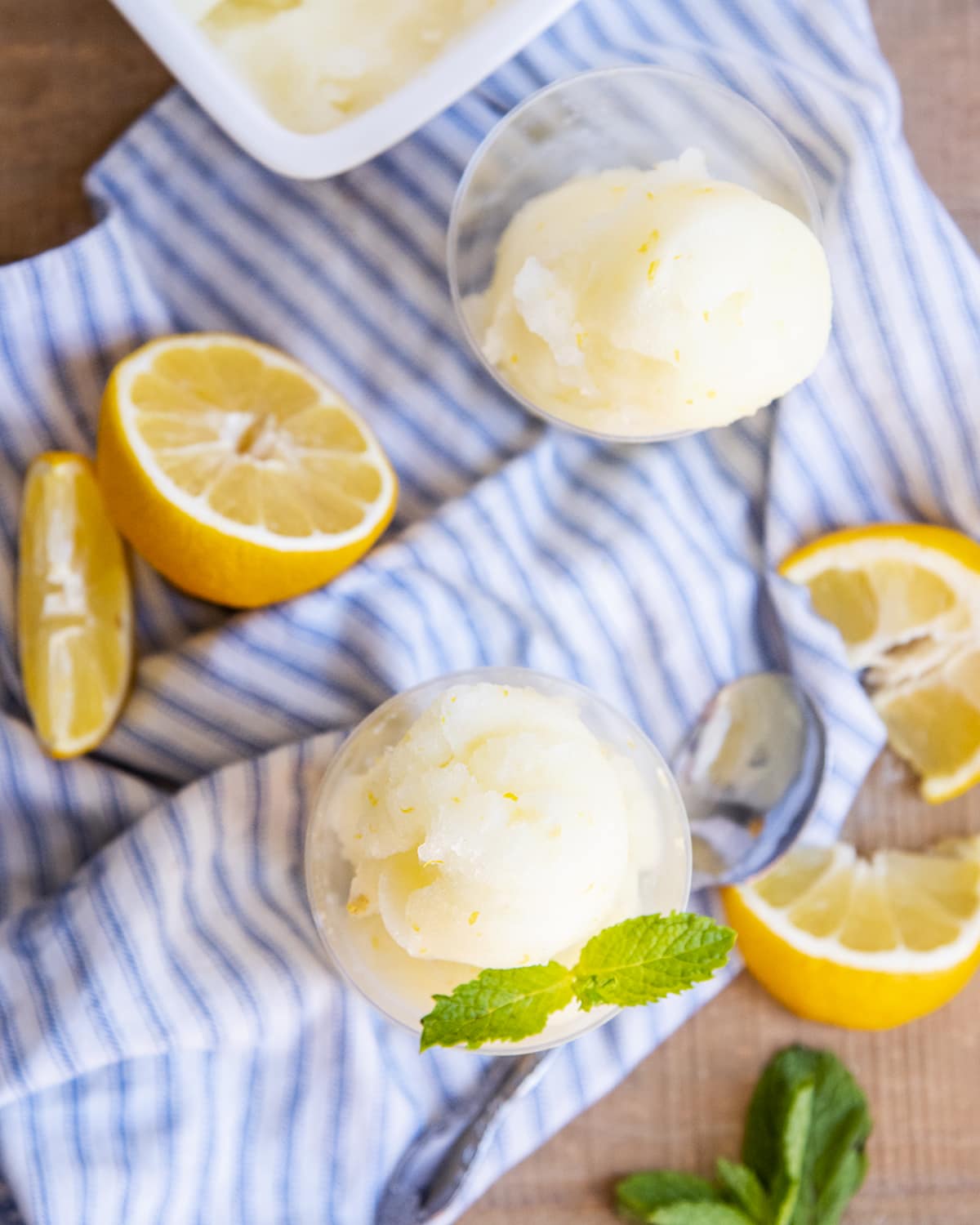 An overhead of two clear cups of lemon sorbet.