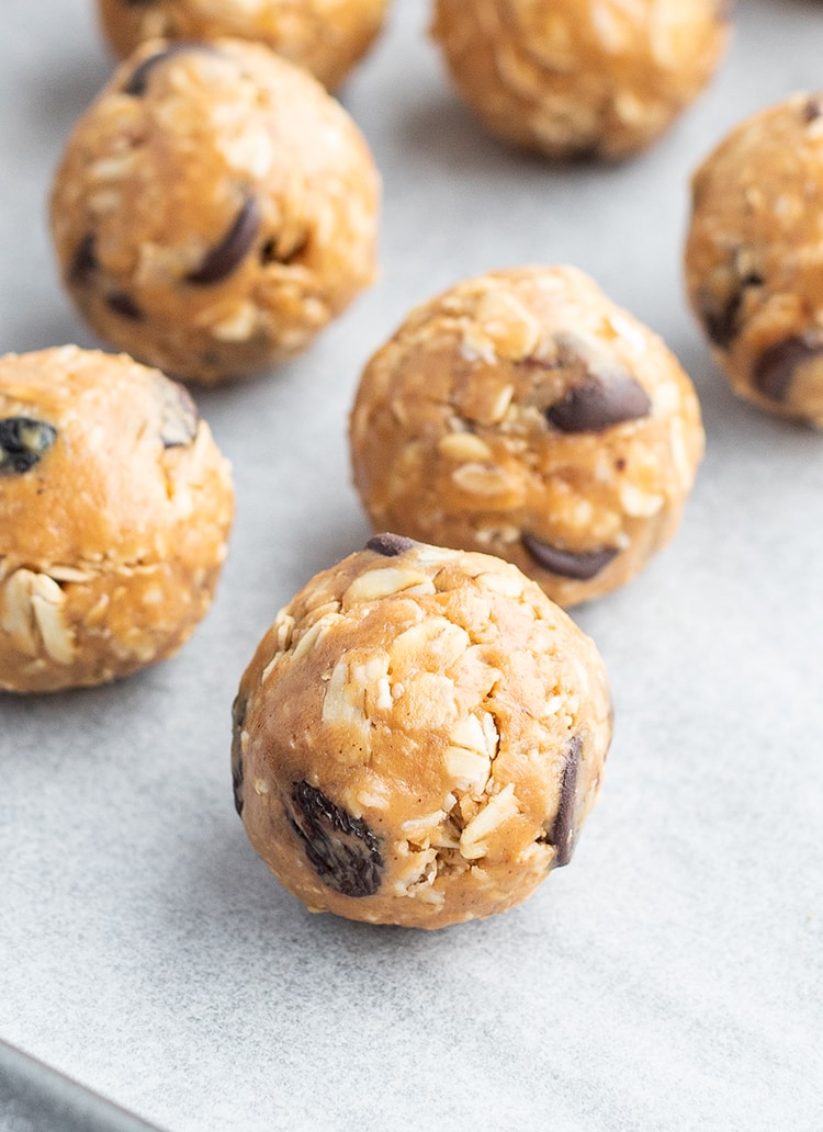 A close up of no bake granola bar bites on a white piece of parchment paper.