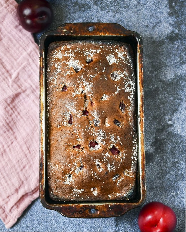 A loaf of plum bread in a pan.