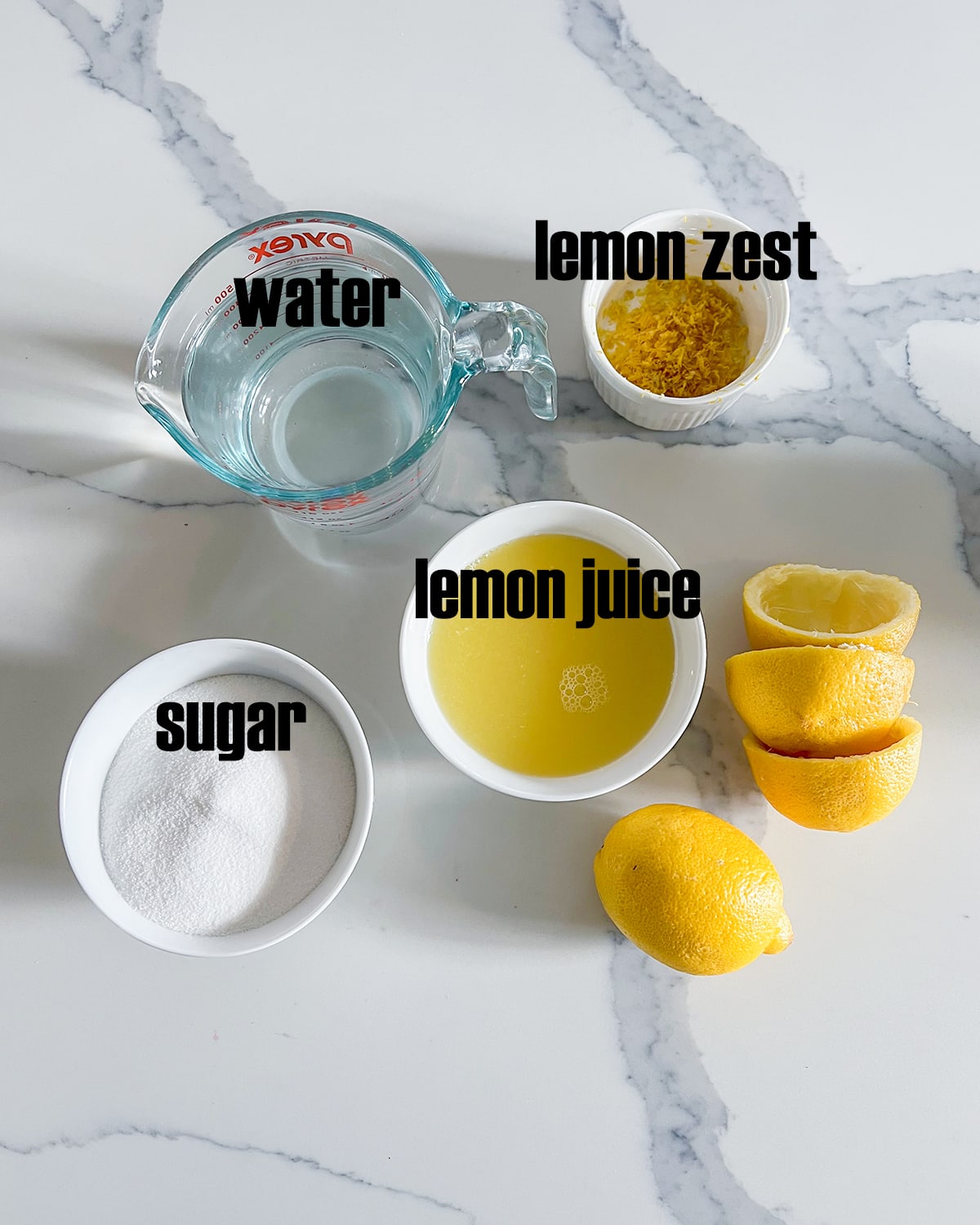 An overhead photo of the ingredients needed to make lemon sorbet. Sugar, water, lemon juice, and lemon zest.