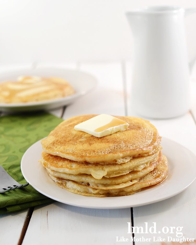 Front view of a stack of pancakes on a white plate.