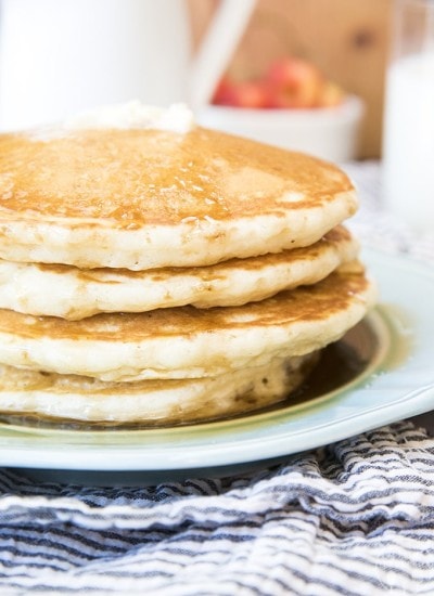 Front view of a stack of perfect pancakes on a blue plate.