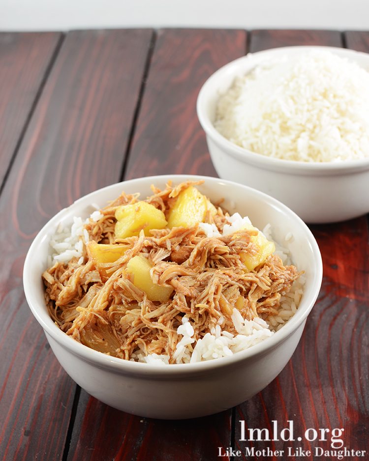 Angled view of hawaiian BBQ chicken over rice in a white bowl.