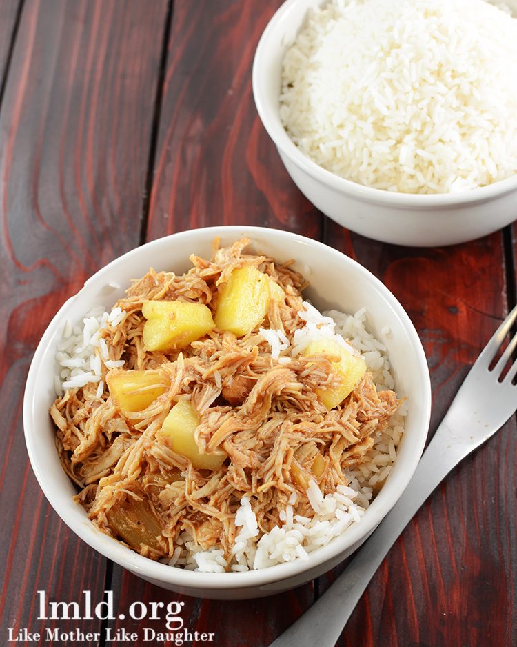 Angled view of hawaiian BBQ chicken over rice in a white bowl.