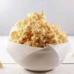 Front view of marshmallow caramel popcorn in a white bowl.