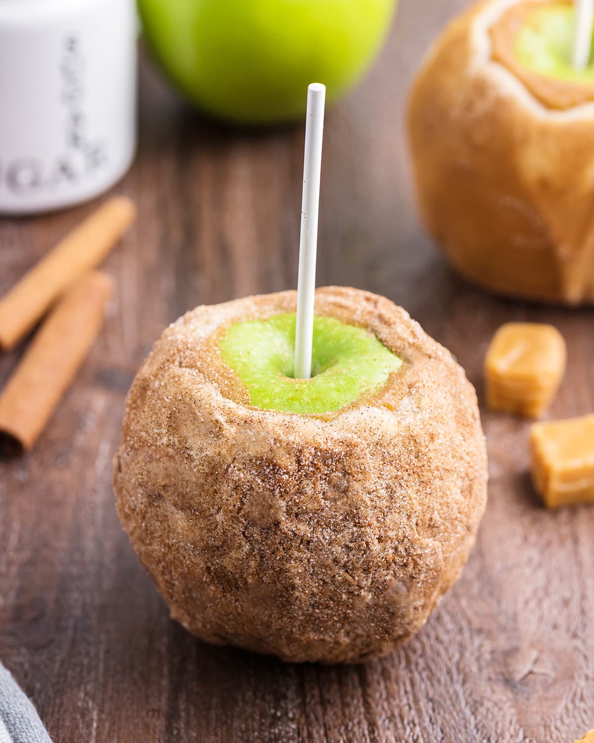 A caramel apple coated in cinnamon sugar.