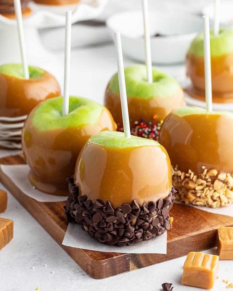 Easy caramel apples are displayed with different candies on caramel on a plate.