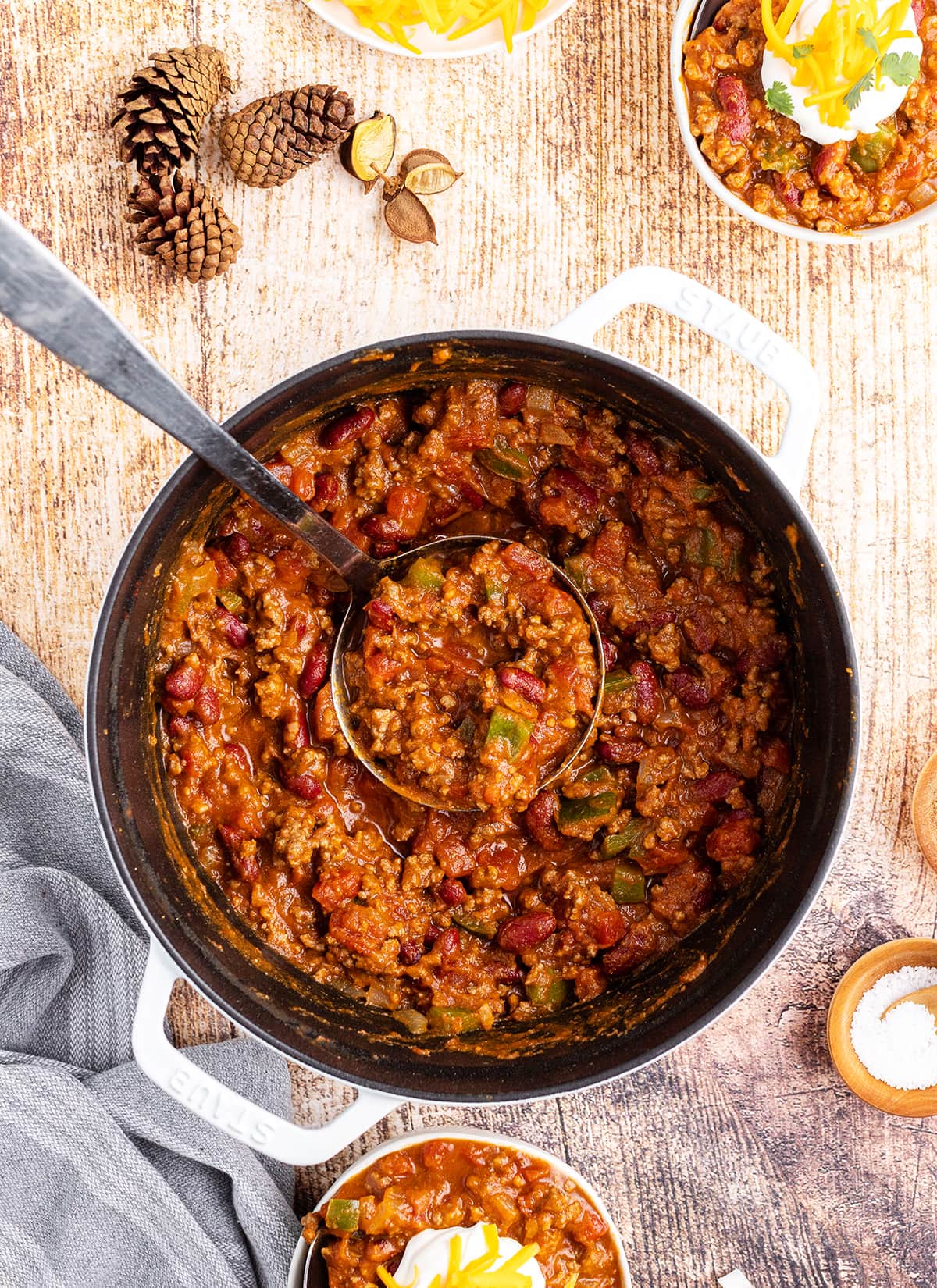 A pot of pumpkin chili with a big ladle in the pot, holding some of the chili.