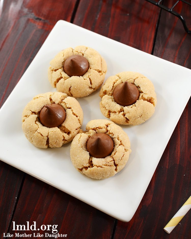 Top view of chocolate blossom cookies on a white plate.