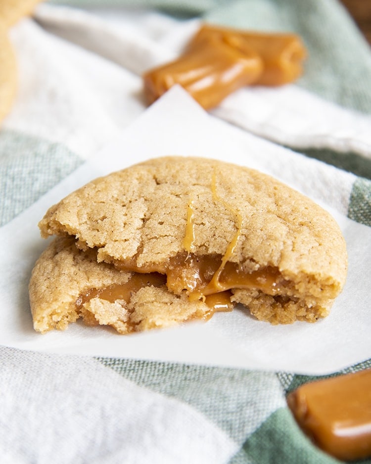 A caramel apple cider cookie broken in half and stacked on top of itself to show the caramel.