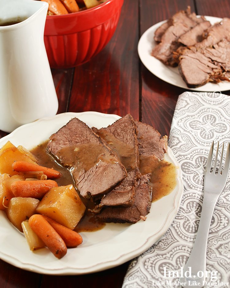 Top view of tavern style crock pot beef roast on a white plate.