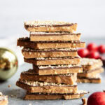 A stack of toffee piece coated in chocolate and cashews.