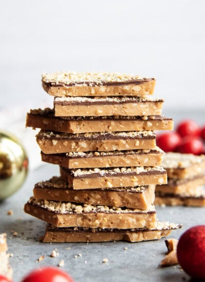 A stack of toffee piece coated in chocolate and cashews.