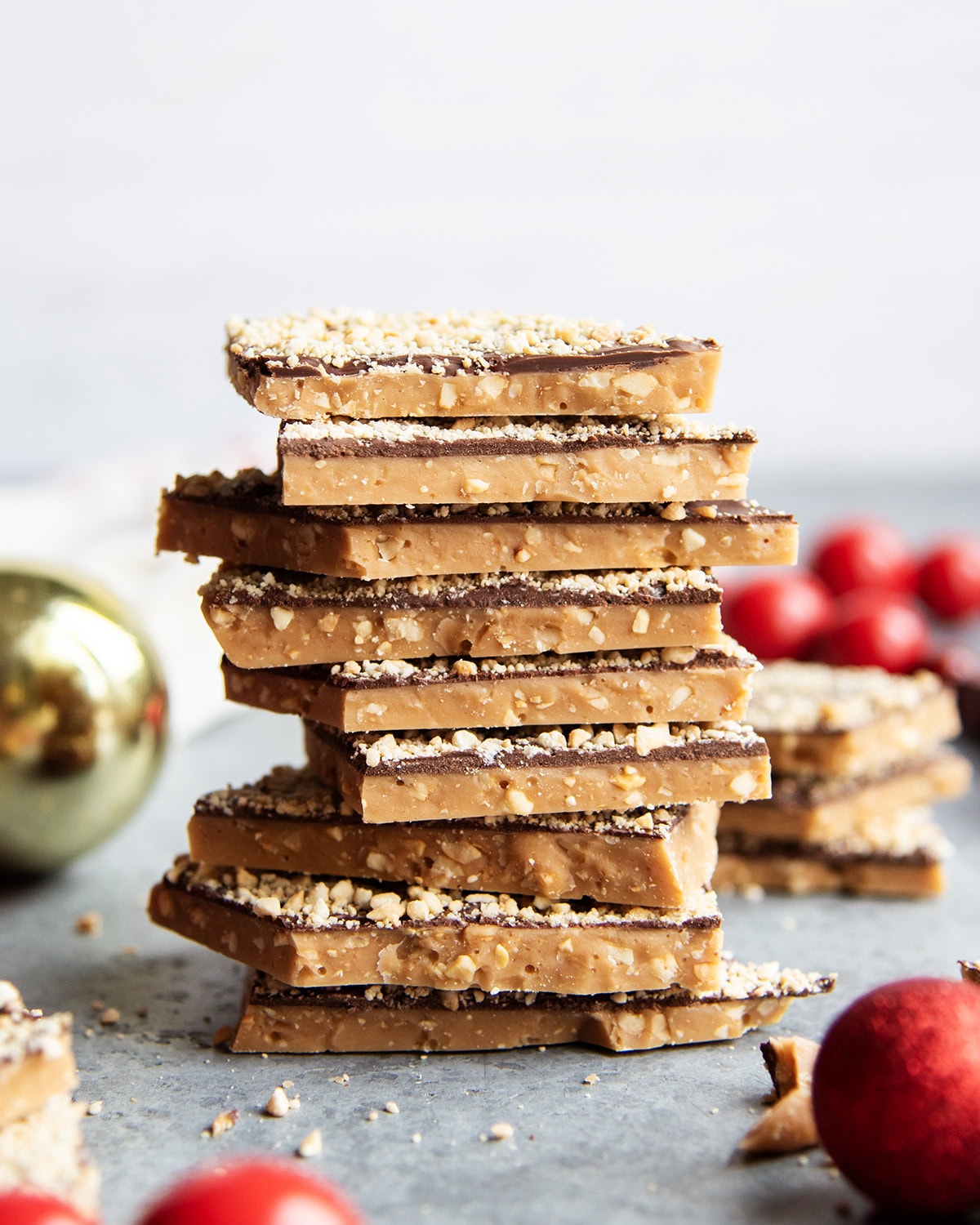 A stack of toffee piece coated in chocolate and cashews.