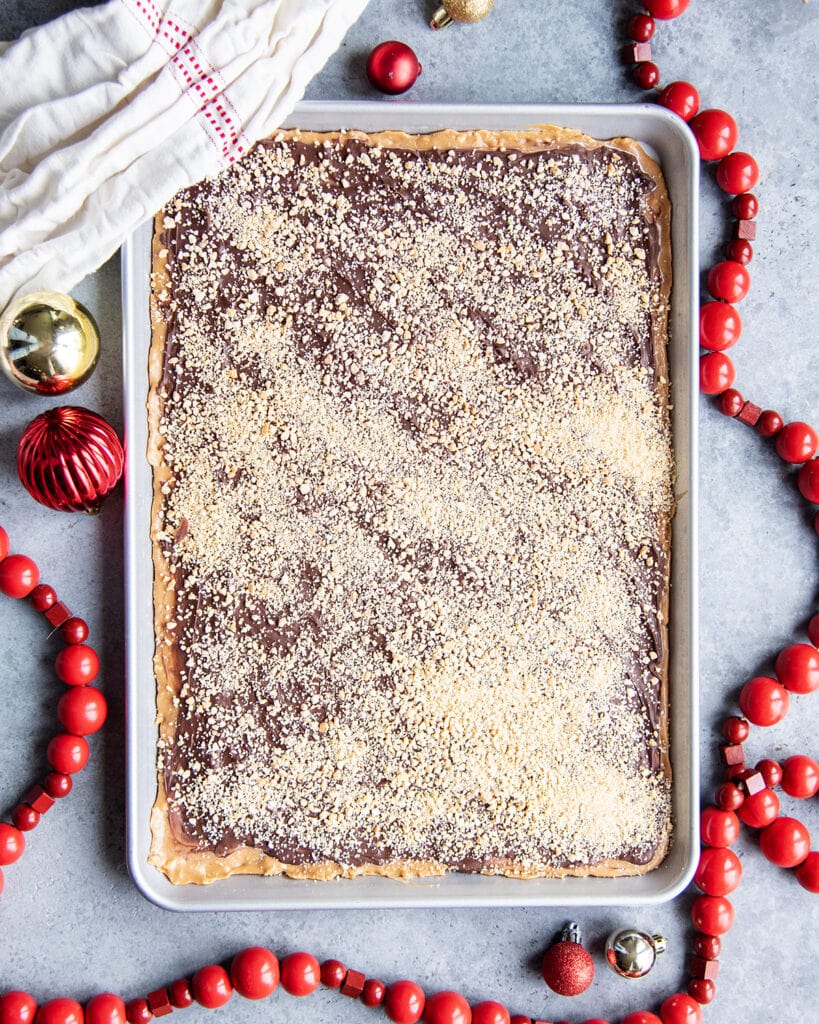 A slab of homemade toffee coated in chocolate in a half sized cookie sheet.