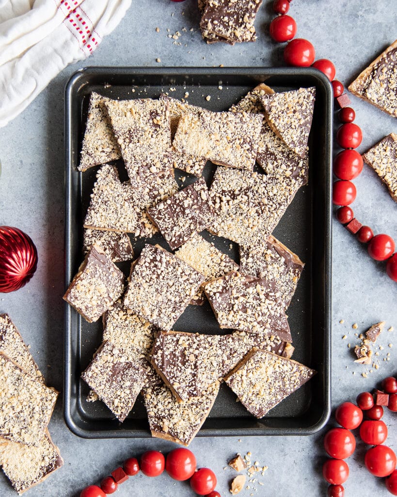 Broken pieces of toffee in a metal cookie sheet.