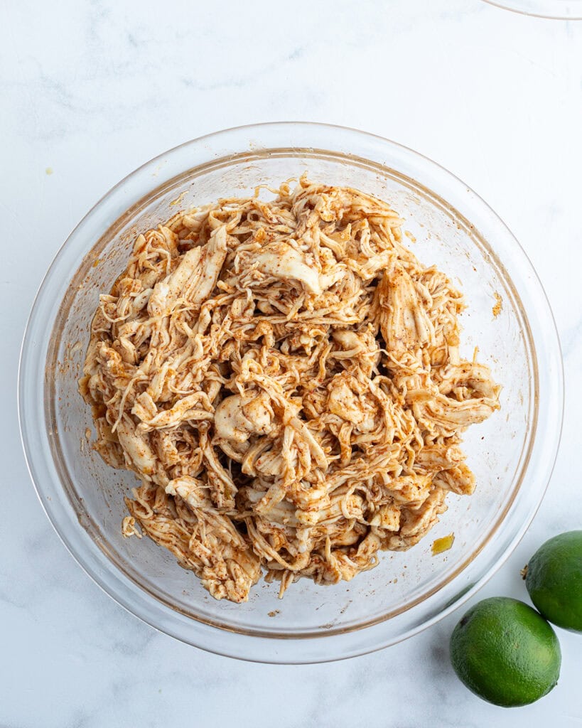 A bowl of chicken topped with seasonings.