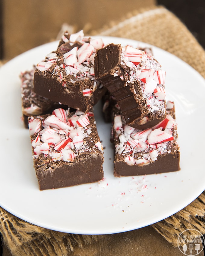 A plate of peppermint fudge, one piece has a bite taken out of it. 