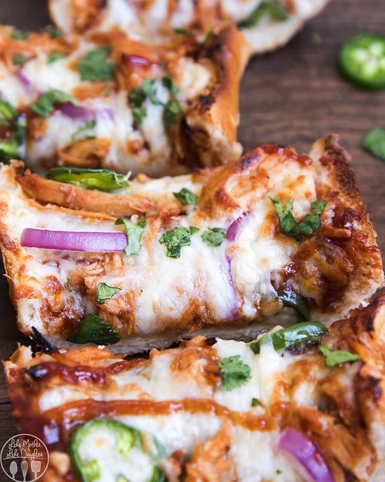 Slices of bbq chicken french bread pizza topped with red onion, and cilantro. 