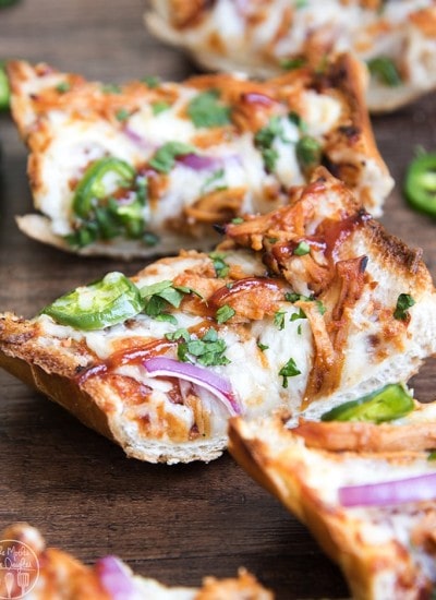 Slices of bbq chicken french bread pizza topped with red onion, and jalapenos.
