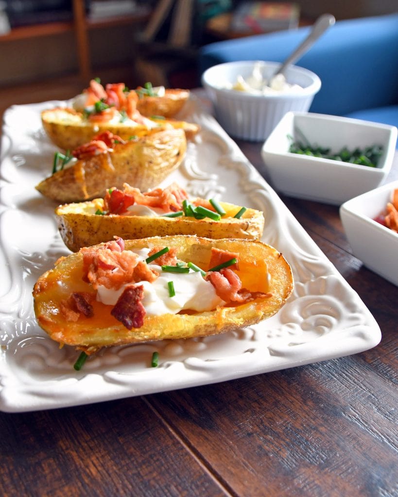 Front view of potato skins on a white plate with toppings.