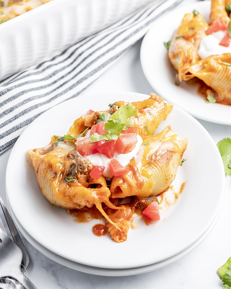 Mexican stuffed shells topped with sour cream and diced tomatoes