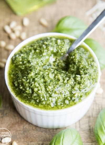 A small bowl of homemade pesto with a spoon in it.