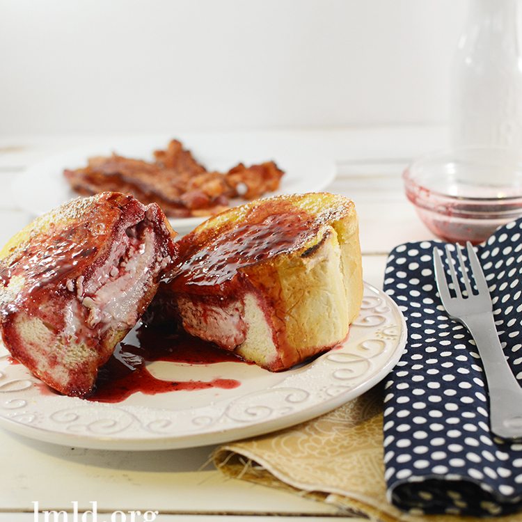 Front view of berry cream cheese stuffed french toast on a white plate.