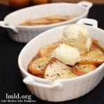 Angled view of caramelized pears with ice cream on top in a white bakeware.
