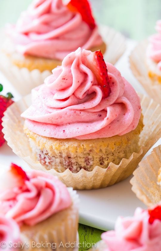 Close up image of strawberry cupcakes with creamy strawberry frosting in a wrapper.