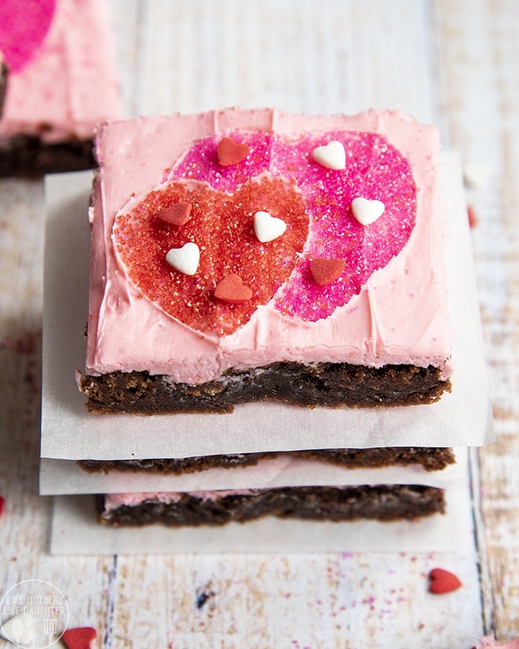 Above shot of stacked valentine\'s day brownies with pink frosting and heart shaped sprinkles.