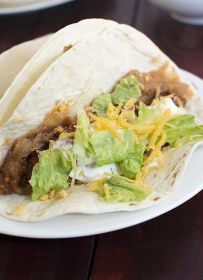 Angled view of easy ground beef tacos on a white plate.