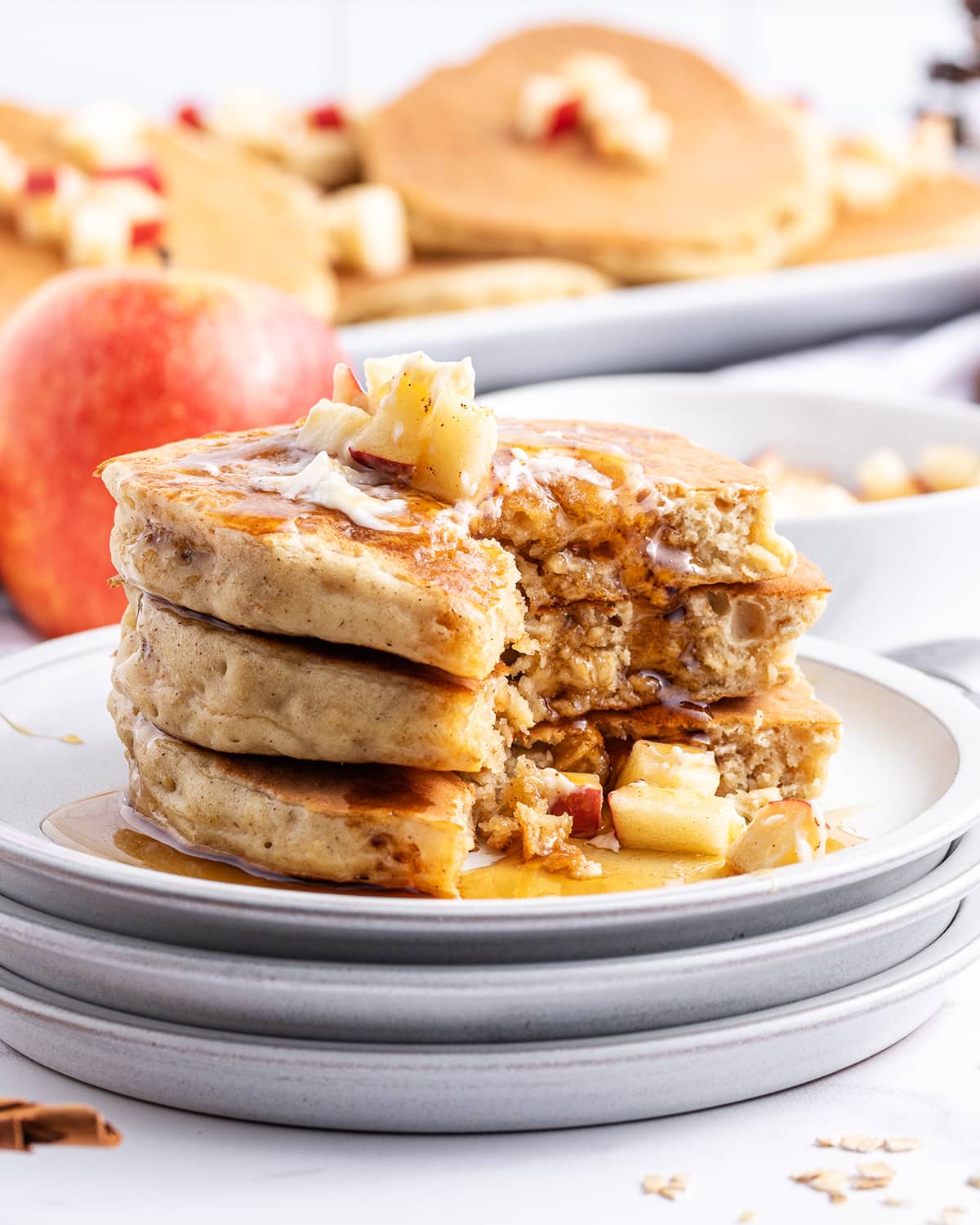 A stack of applesauce pancakes with a few bites cut out of the stack.