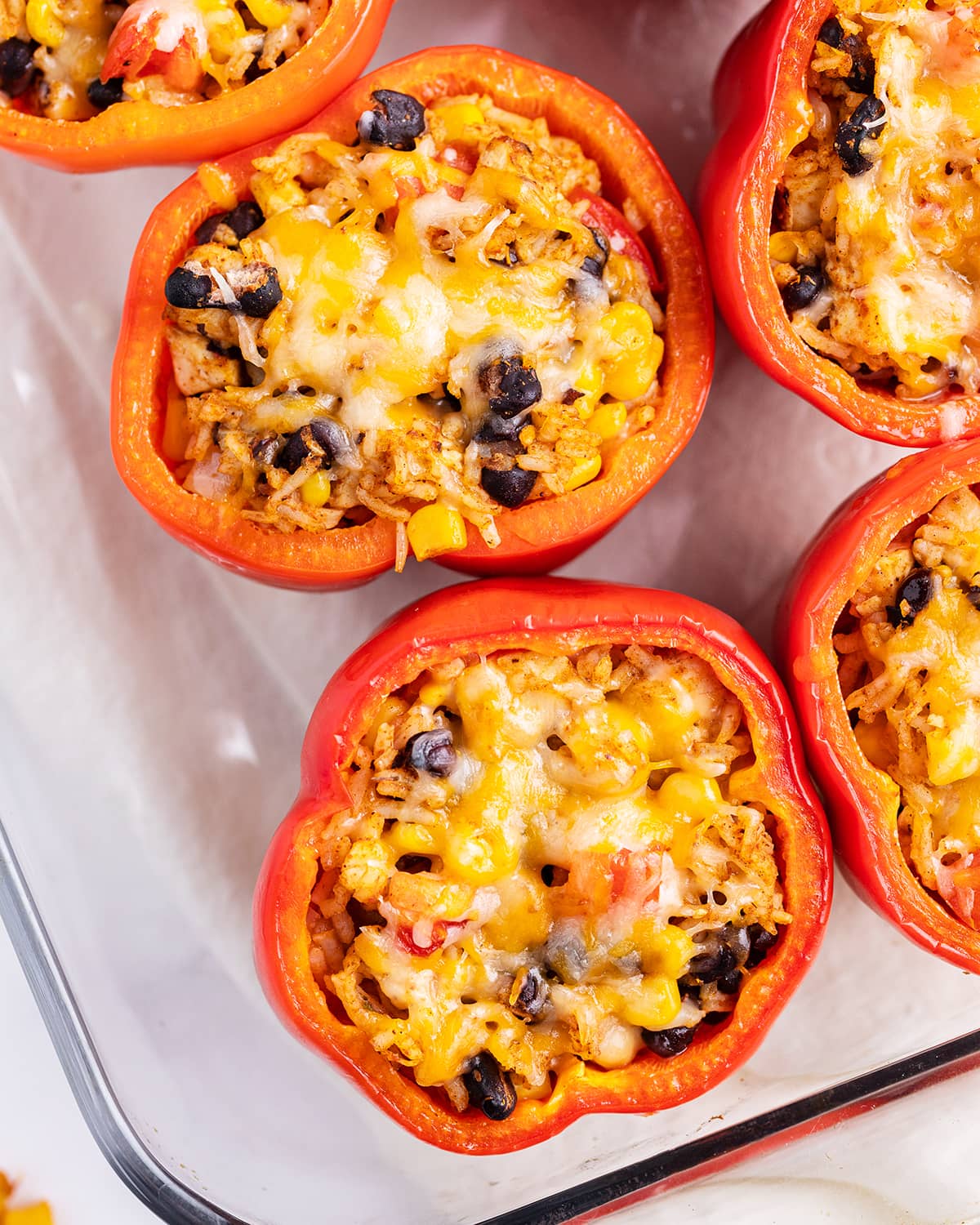 An overhead shot of Mexican stuffed peppers in a glass baking dish.