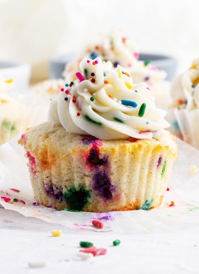 A funfetti cupcake with buttercream frosting and more sprinkles on top.