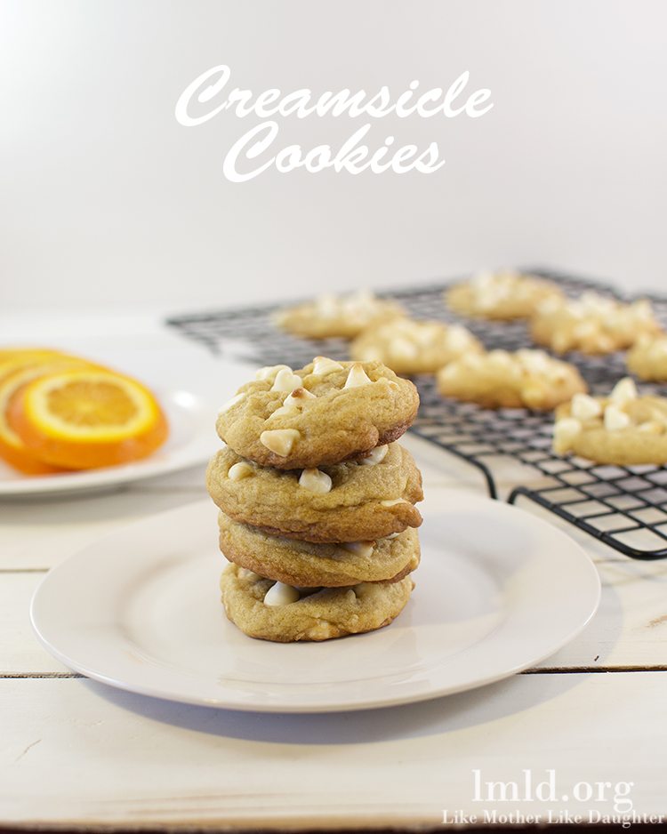 Front view of creamsicle cookies stacked on a white plate.