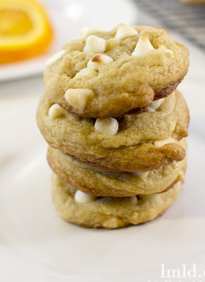 Front view of creamsicle cookies stacked on a white plate.